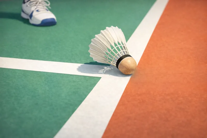 バドミントンのイン・アウト判定を示すイラスト｜シャトルのコルクがコートのライン上に触れている瞬間