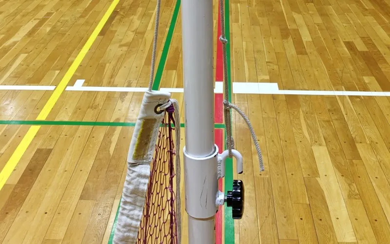 支柱のフックにバドミントンネットのロープを掛けて片側を仮止めした状態
